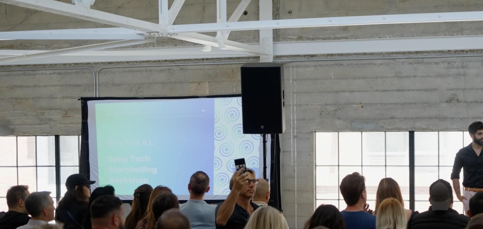 A full room at the Deep Tech Storytelling Workshop, Spiral's title slide on the screen.